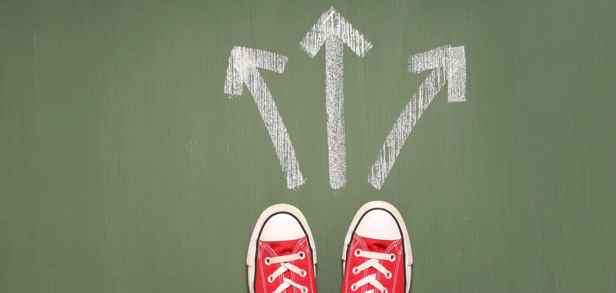 Taking decisions Füße einer Person stehen vor drei Pfeilen, die in unterschiedliche Richtungen zeigen.