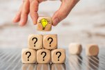 Question and answer as teamwork Kleine Pyramide aus Würfeln mit Fragezeichen, oberster Würfel hat eine Glühbirne auf der vorderen Seite