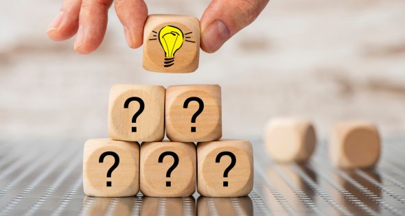 Question and answer as teamwork Kleine Pyramide aus Würfeln mit Fragezeichen, oberster Würfel hat eine Glühbirne auf der vorderen Seite