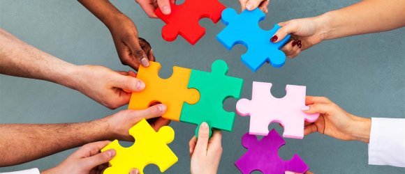 Hände mit bunten Puzzle-Teilen