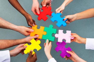 Hände mit bunten Puzzle-Teilen