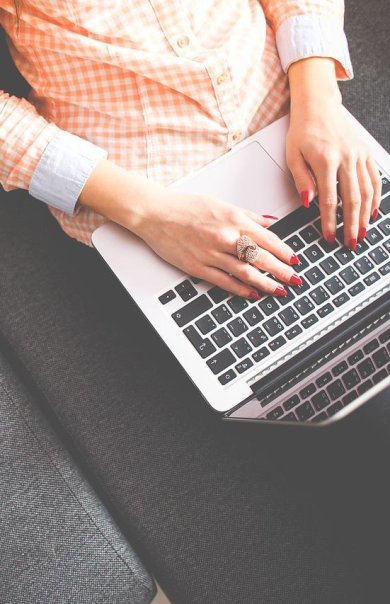 Weibliche Person mit Laptop auf dem Schoß von schräg oben fotografiert