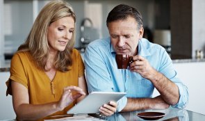 Paar mittleren Alters vor einem Tablet