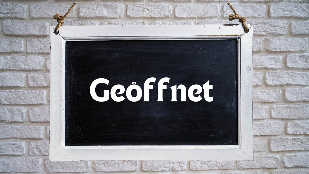 Tafel an einer Steinmauer mit der Aufschrift geöffnet