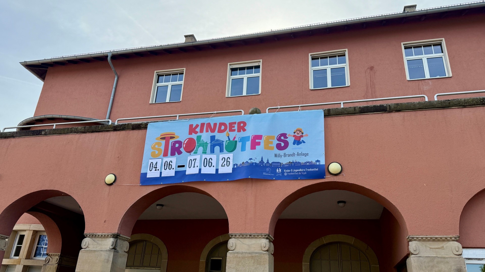 Bild von Zuckerfabrik mit Banner an der Hauswand mit Hinweisen zum Kinderstrohhutfest