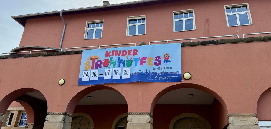Bild von Zuckerfabrik mit Banner an der Hauswand mit Hinweisen zum Kinderstrohhutfest