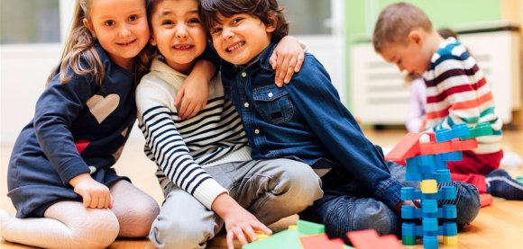 Drei Kinder umarmen sich