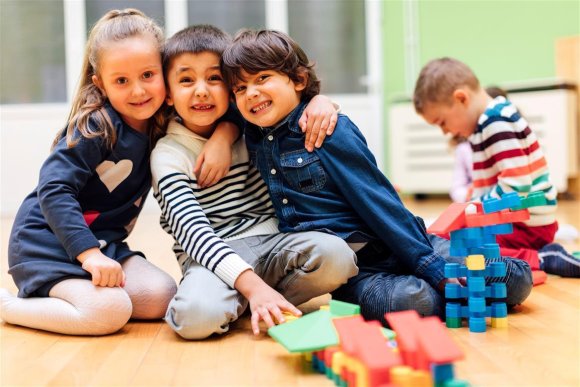 Drei Kinder umarmen sich