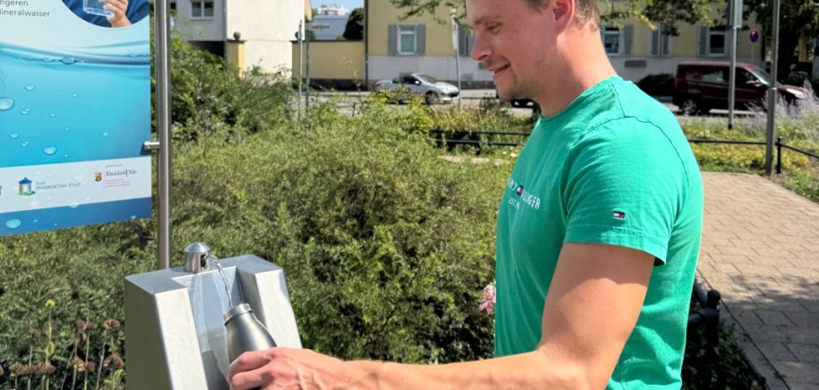 Mann an einem Trinkwasserbrunnen