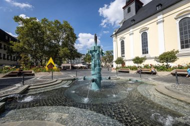 Brunnen auf einem Platz mit Kirche im Hintergrund