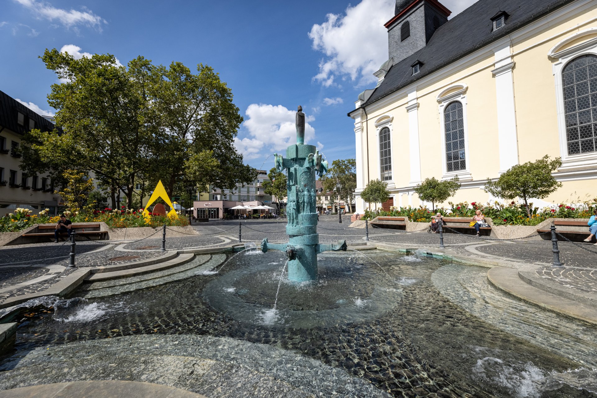 Brunnen auf einem Platz mit Kirche im Hintergrund