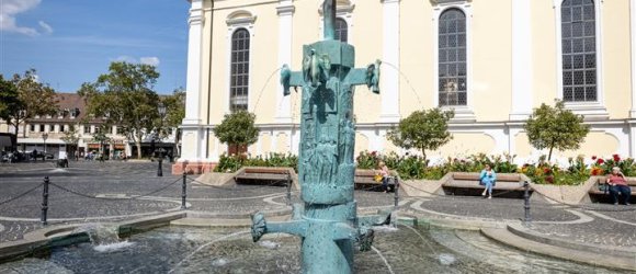 Brunnen auf einem Platz mit Kirche im Hintergrund