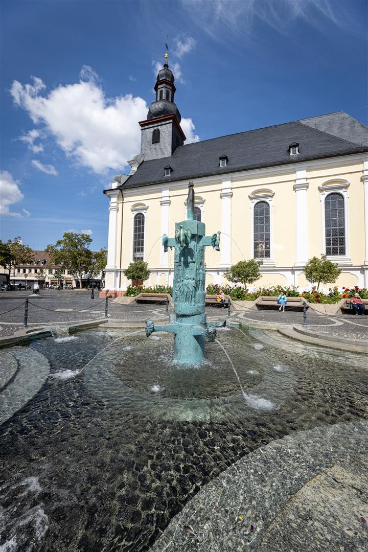 Brunnen auf einem Platz mit Kirche im Hintergrund