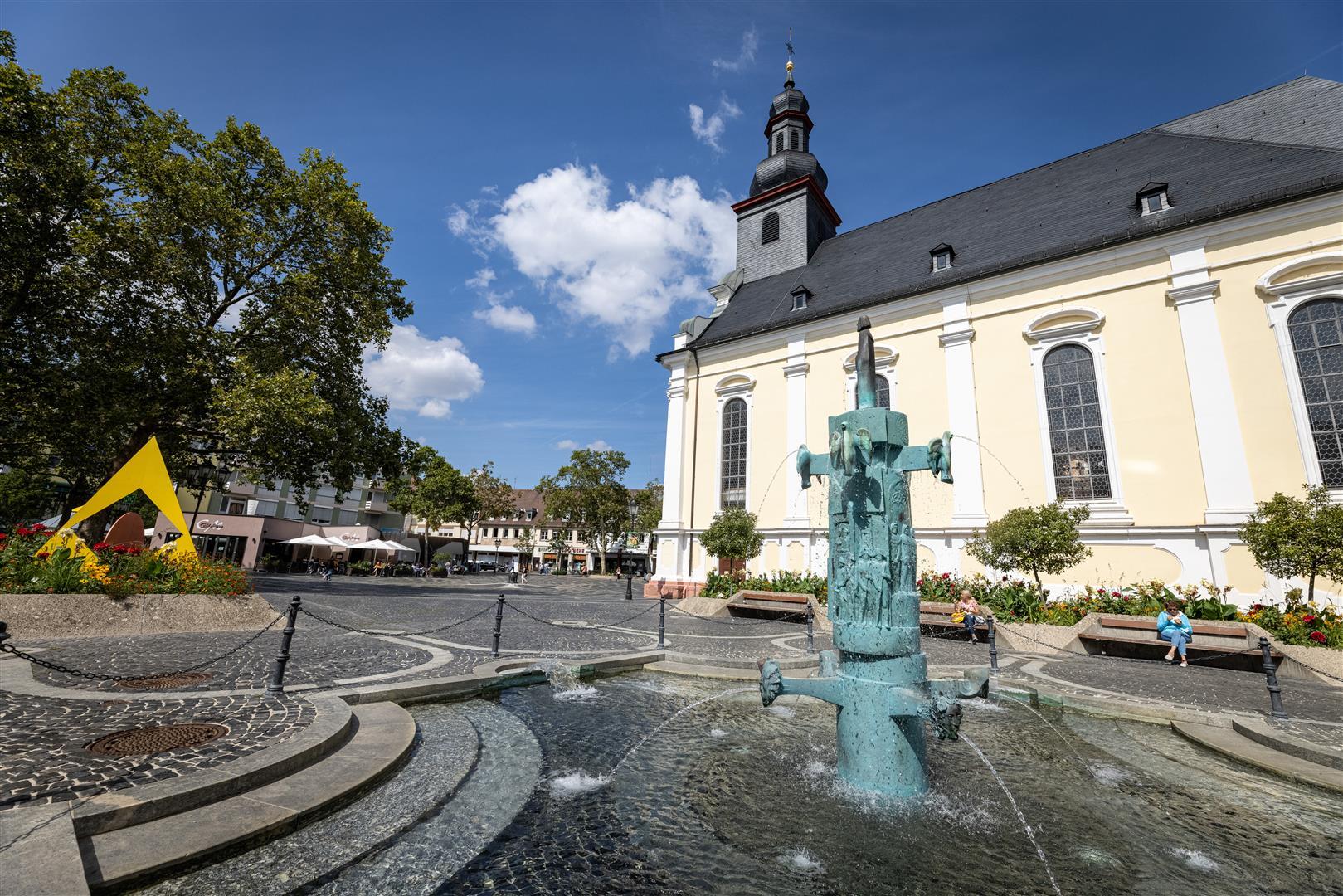 Brunnen auf einem Platz mit Kirche im Hintergrund