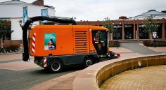 Kehrmaschine Mina-Karcher-Platz Brunnen Eine Kehrmaschine mit Saugvorrichtung auf dem Mina-Karcher Platz wie sie den Brunnen kehrt. Im Hintergrund das Congressforum