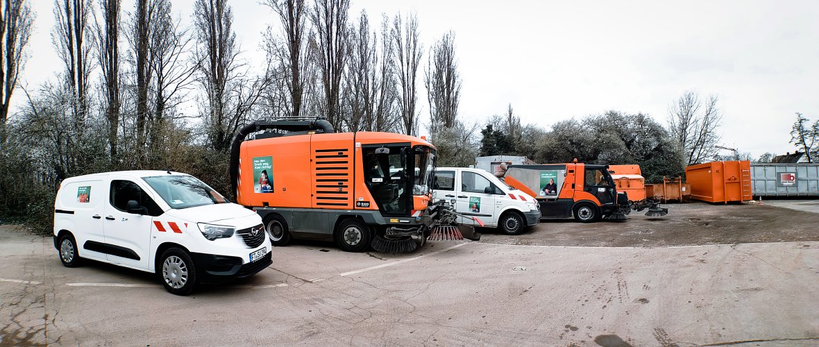 Vier Fahrzeuge der Straßenreinigung in Reihe auf dem Wertstoffcenter aufgestellt mit den Motiven der Anti-Littering-Kampagne