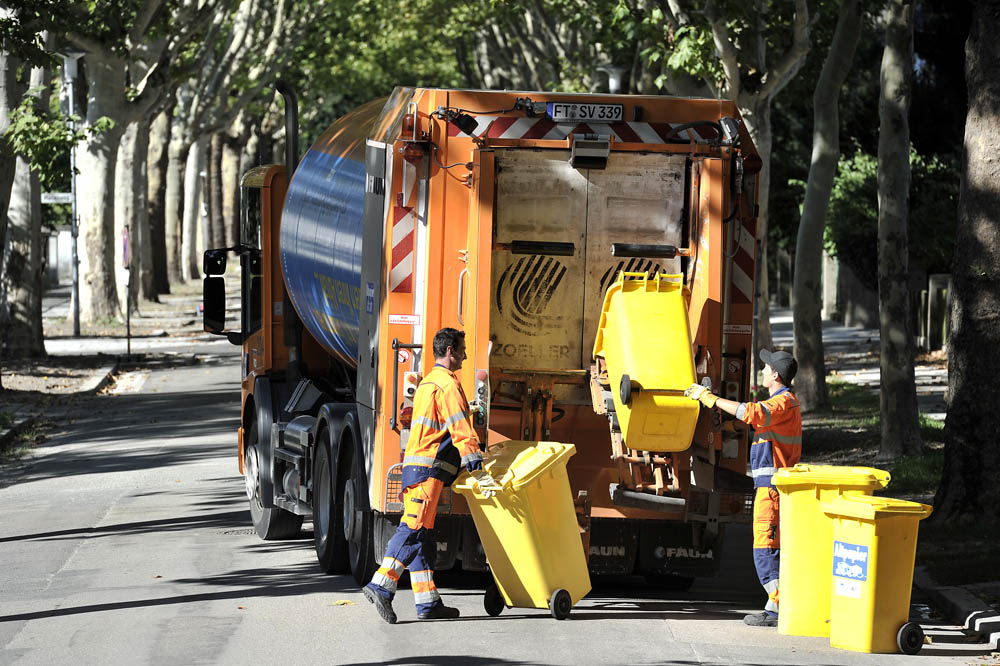Müllwerker beim Leeren der Papiertonne