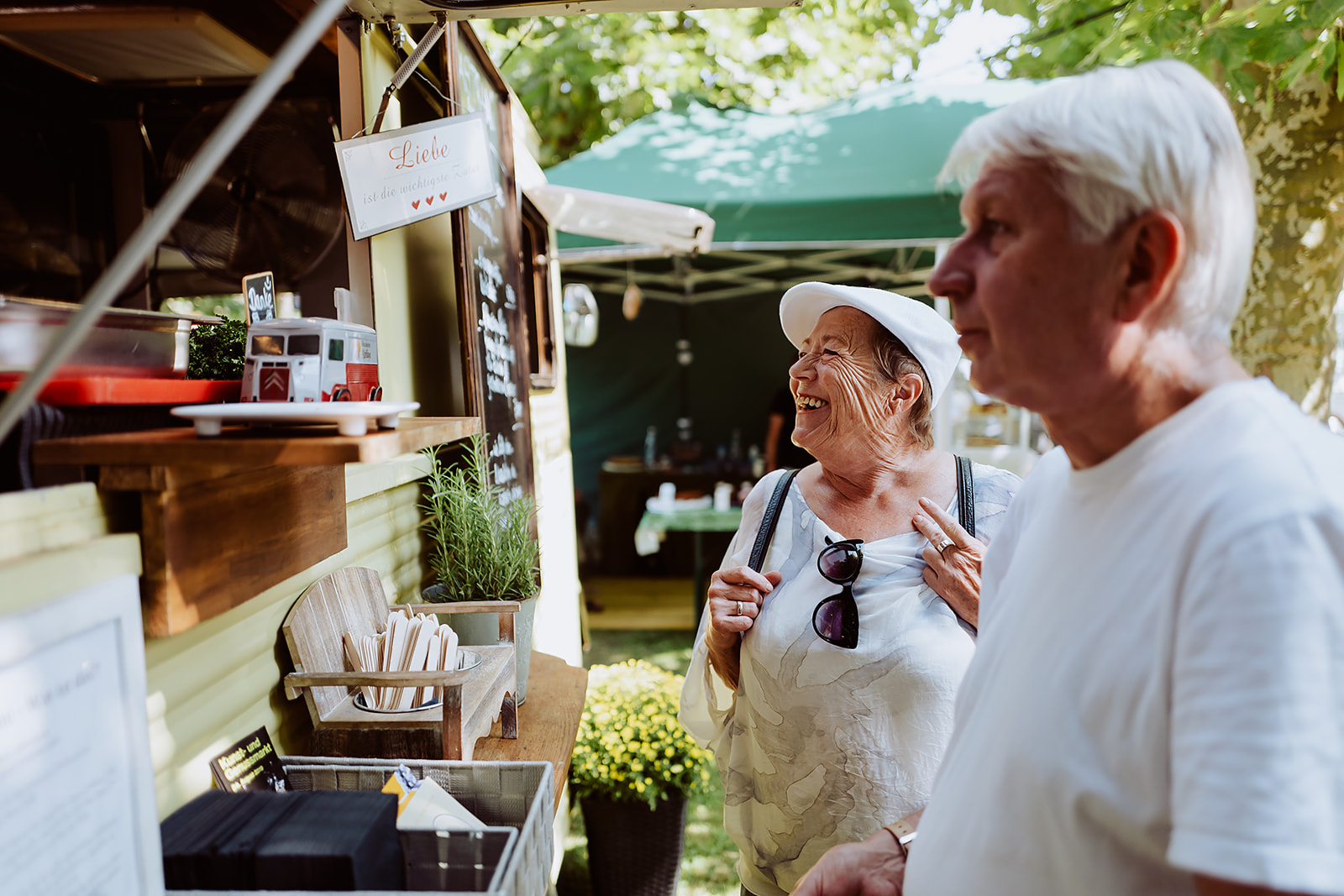 Menschen lesen eine Tafel an einem Foodtruck