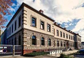 Großes Gebäude mit zwei Fensterreihen übereinander.