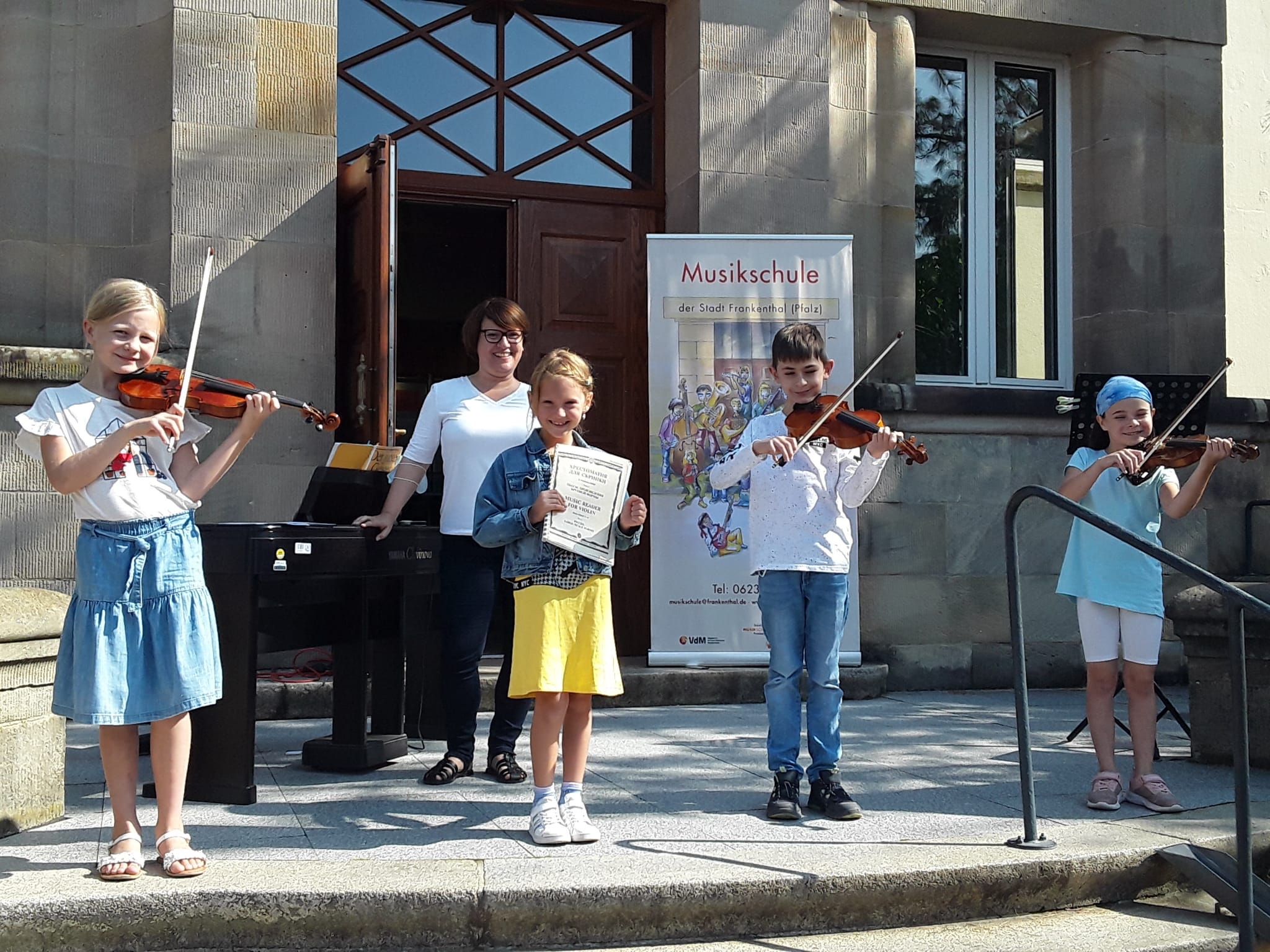 musizierende Kinder vor der Musikschule