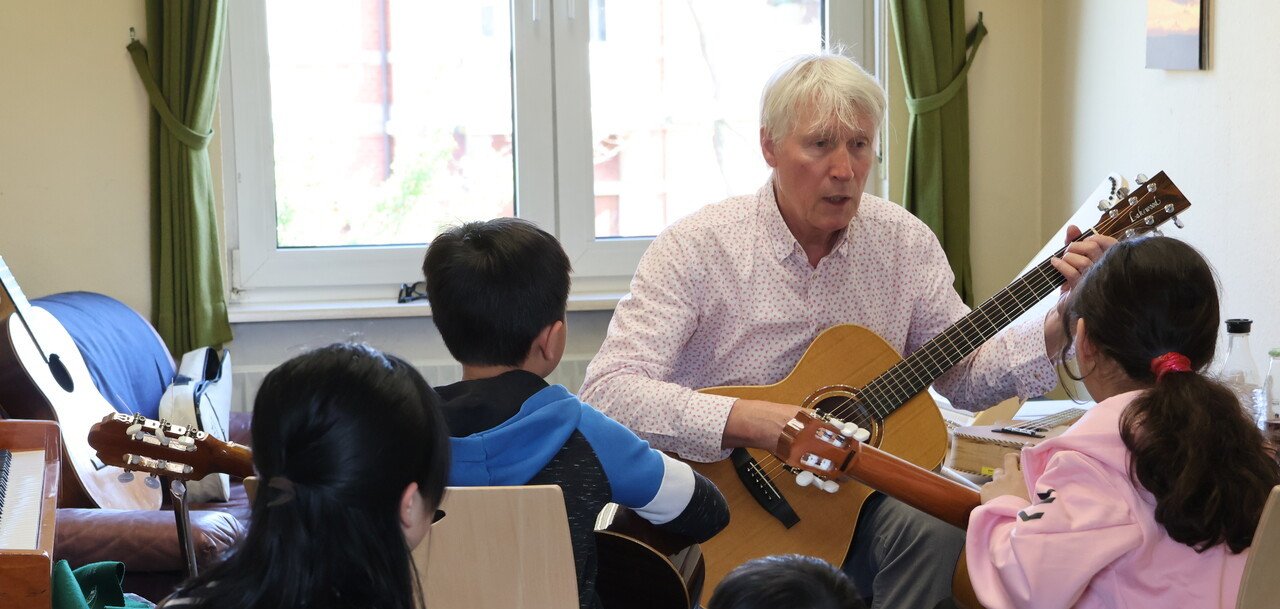 Kinder beim Ausprobieren von Musikinstrumenten