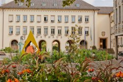Blumenbeete vor einem Gebäude mit Arkaden
