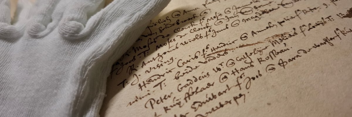 Eintrag im Kirchenbuch der niederländisch reformierten Gemeinde, 1591 Nahaufnahme eines Eintrags im Kirchenbuch der niederländisch reformierten Gemeinde von 1591, beiliegend ein Baumwollhandschuh