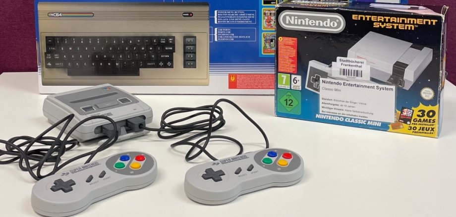 Retro-Konsolen zum Ausleihen Auf dem Bild sind insgesamt vier verschiedene Retrokonsolen zu sehen, die in der Stadtbücherei ausgeliehen werden können. Hierbei handelt es sich Atari 2600+, Sega Mega Drive Flashback, C64, SNES Classic Mini.