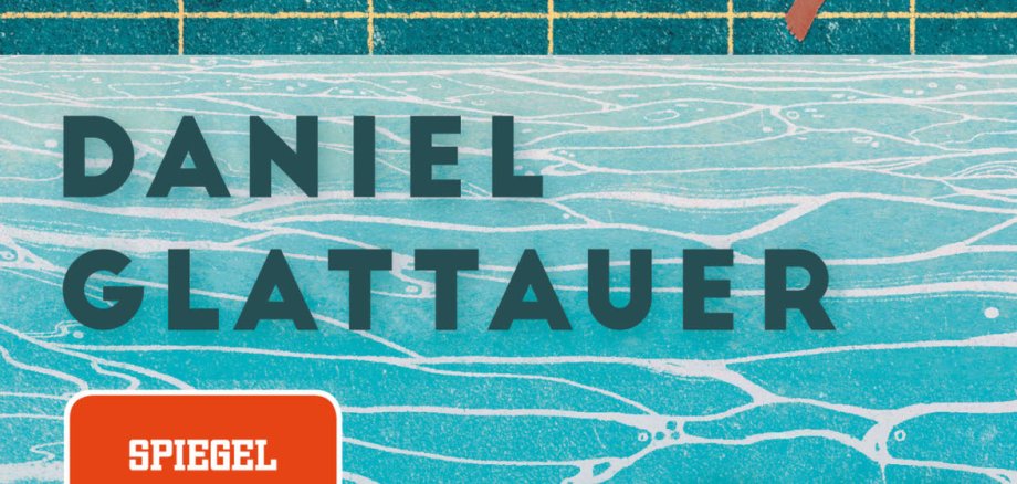 Zu sehen ist ein Buchcover auf dem ein Schwimmbecken mit Beckenrand abgebildet ist. Oben links streckt eine Person einen Fuß ins Wasser. Auf dem Cover steht: Daniel Glattauer / Die spürst du nicht / Spiegel Bestseller und unten links Roman Zsolnay