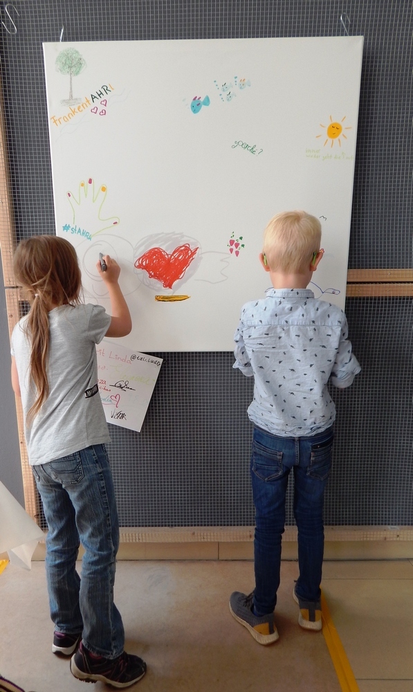 Workshop zu "Flutgeschichten" am 19.08.2022 Workshop zu "Flutgeschichten" am 19.08.2022. Zwei Kinder malen ein Plakat