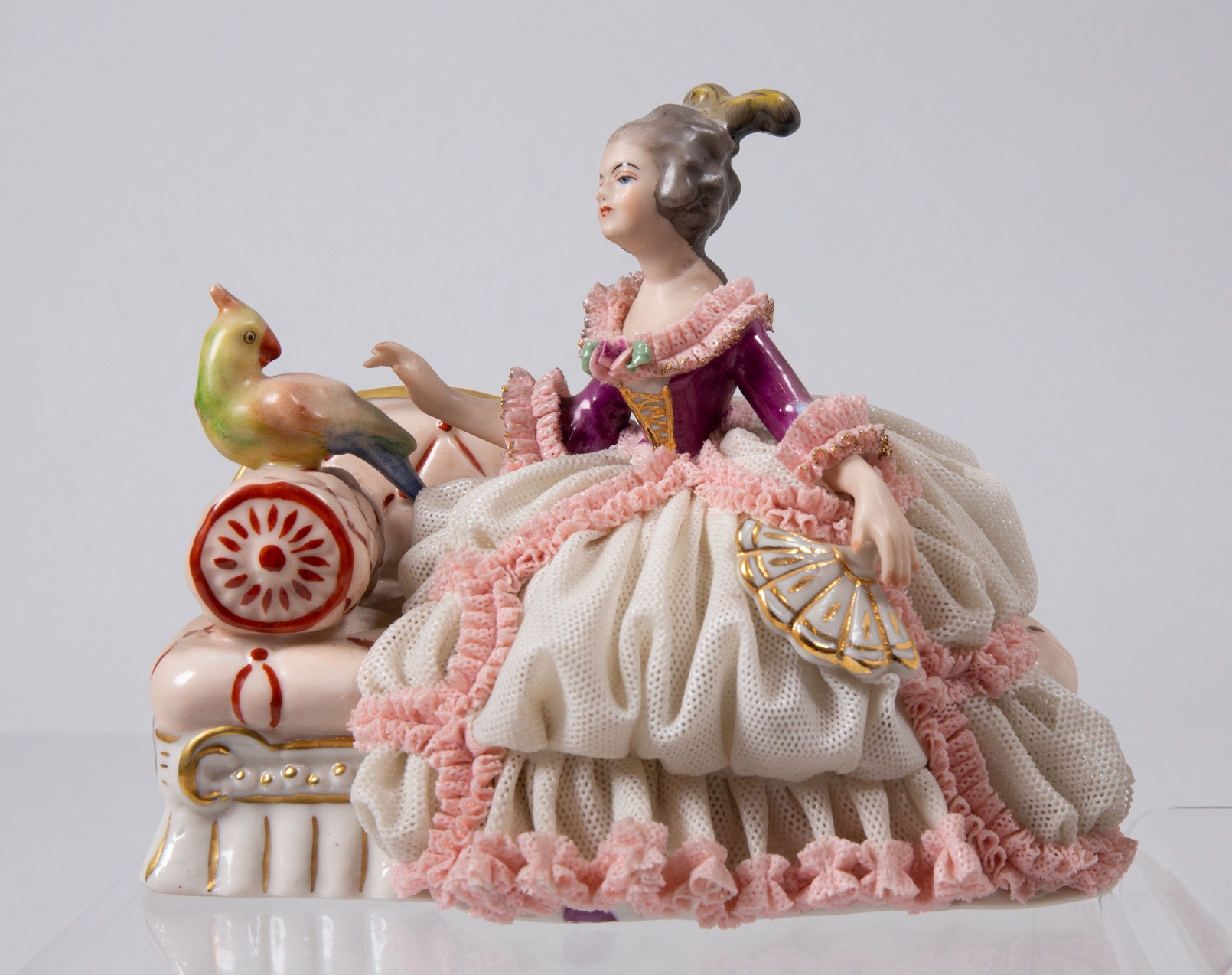 Das Objekt des Monats März 2023: Porzellanfigur der Manufaktur Friedrich Wessel, eine Dame auf einem kleinen Sessel mit einem Vogel, der auf der Lehne sitzt, darstellend.