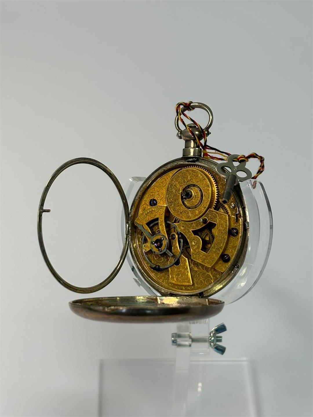 Schweizer Manufaktur (?), Taschenuhr, 1880-1889 Fotografie einer vermutlich aus der Schweiz stammenden Taschenuhr im geöffneten Zustand mit Blick auf das reich verzierte Uhrwerk.
