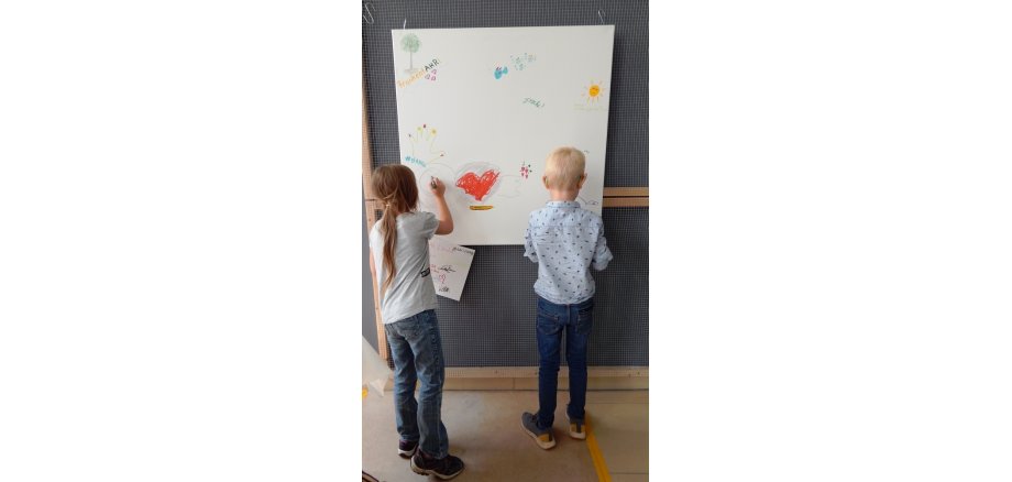 Workshop zu "Flutgeschichten" am 19.08.2022. Zwei Kinder malen ein Plakat