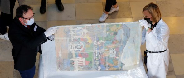 Eines der beschädigten Gemälde wird begutachtet