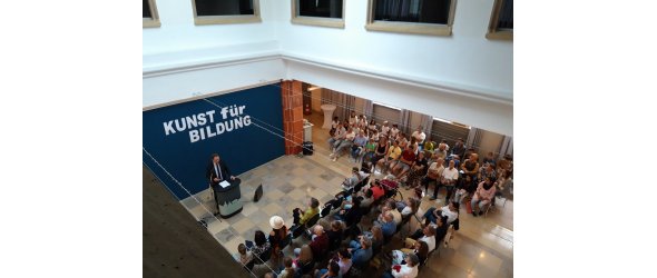 Auktion bei der Ausstellung "Kunst für Bildung". Vor zahlreichen Besucherinnen und Besuchern hält Oberbürgermeister Martin Hebich die Eröffnungsrede im Foyer des Erkenbert-Museums.