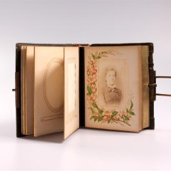 Fotoalbum mit integrierter Spieluhr im geöffneten Zustand mit historischer Fotografie einer unbekannten Frau.