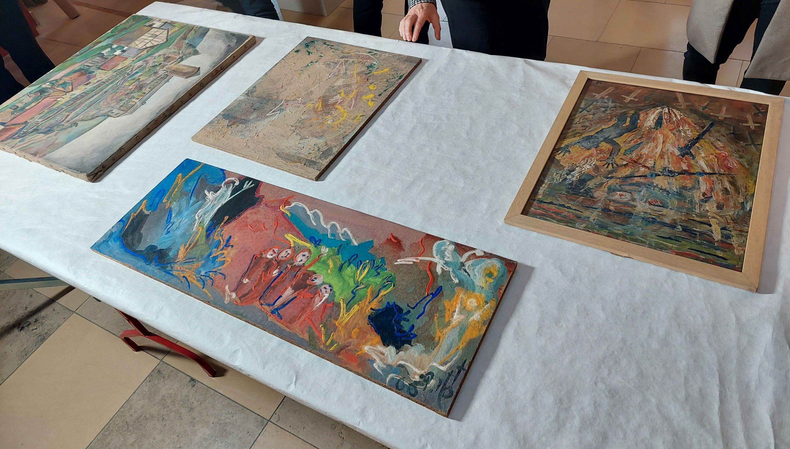 Auf dem Tisch ausgebreitet werden die beschädigten Gemälde aus dem Ahrtal nach ihrer Annahme zur Restaurierung das erste Mal  begutachtet