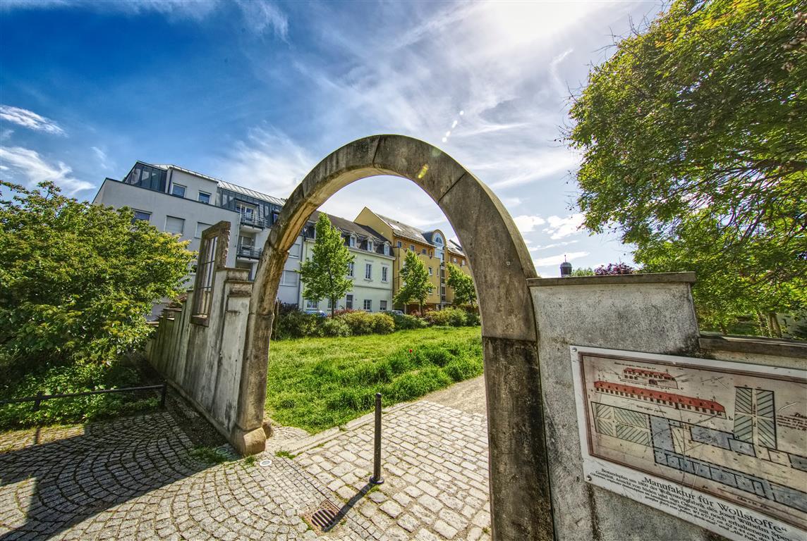 Tor aus Stein zu einer Grünanlage