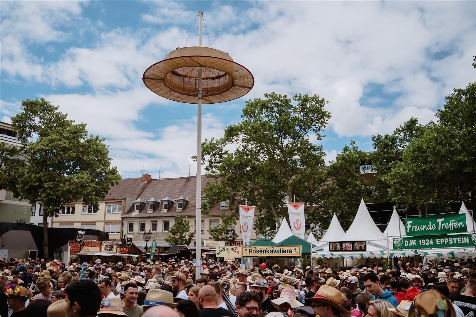 Großer Strohhut und Menschenmenge am Rathausplatz