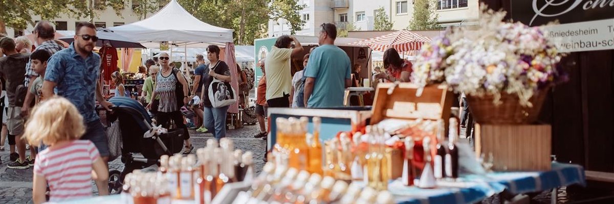 Bauernmarkt 2019_Foto_Pressestelle FT, Sebastian Weindel (50) (Medium) Blick auf den Rathausplatz mit Ständen und Menschen. Der Himmel ist blau. Im Vordergrund ein Marktstand.
