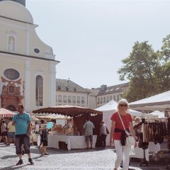 Blick über den Rathausplatz mit Ständen und Menschen auf die Kirche.