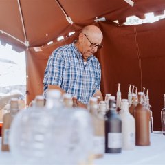 Mann und Frau in einem Marktstand mit Likören.