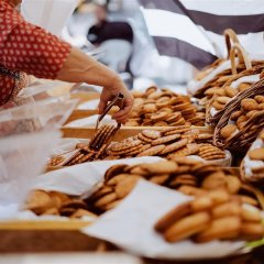 Frau Blanche packt Elsässer Buttergebäck aus der Auslage in eine Tüte ein.