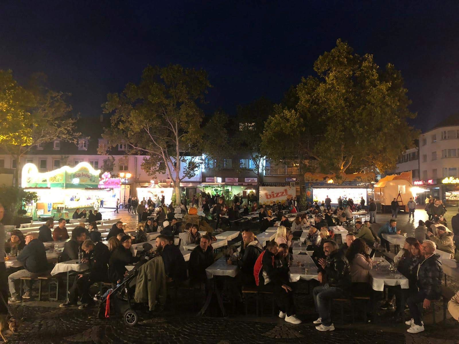 Herbstspektakel 2019-5_Foto_Oksana Ksionsek Menschen sitzen an Biergarnituren bei Nacht.