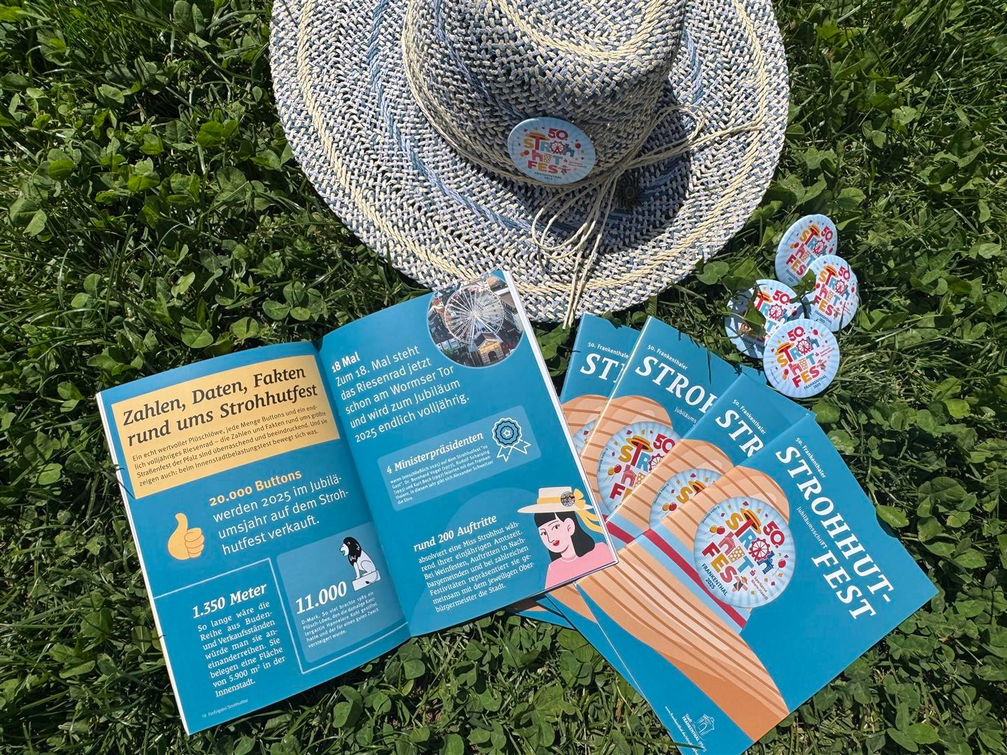 Mehrere Hefte, Buttons und ein Strohhut