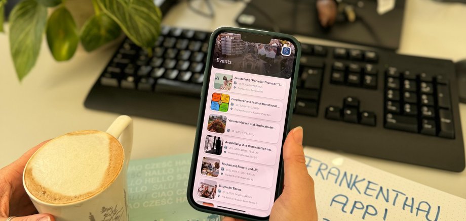 Handy-Display in Hand vor PC