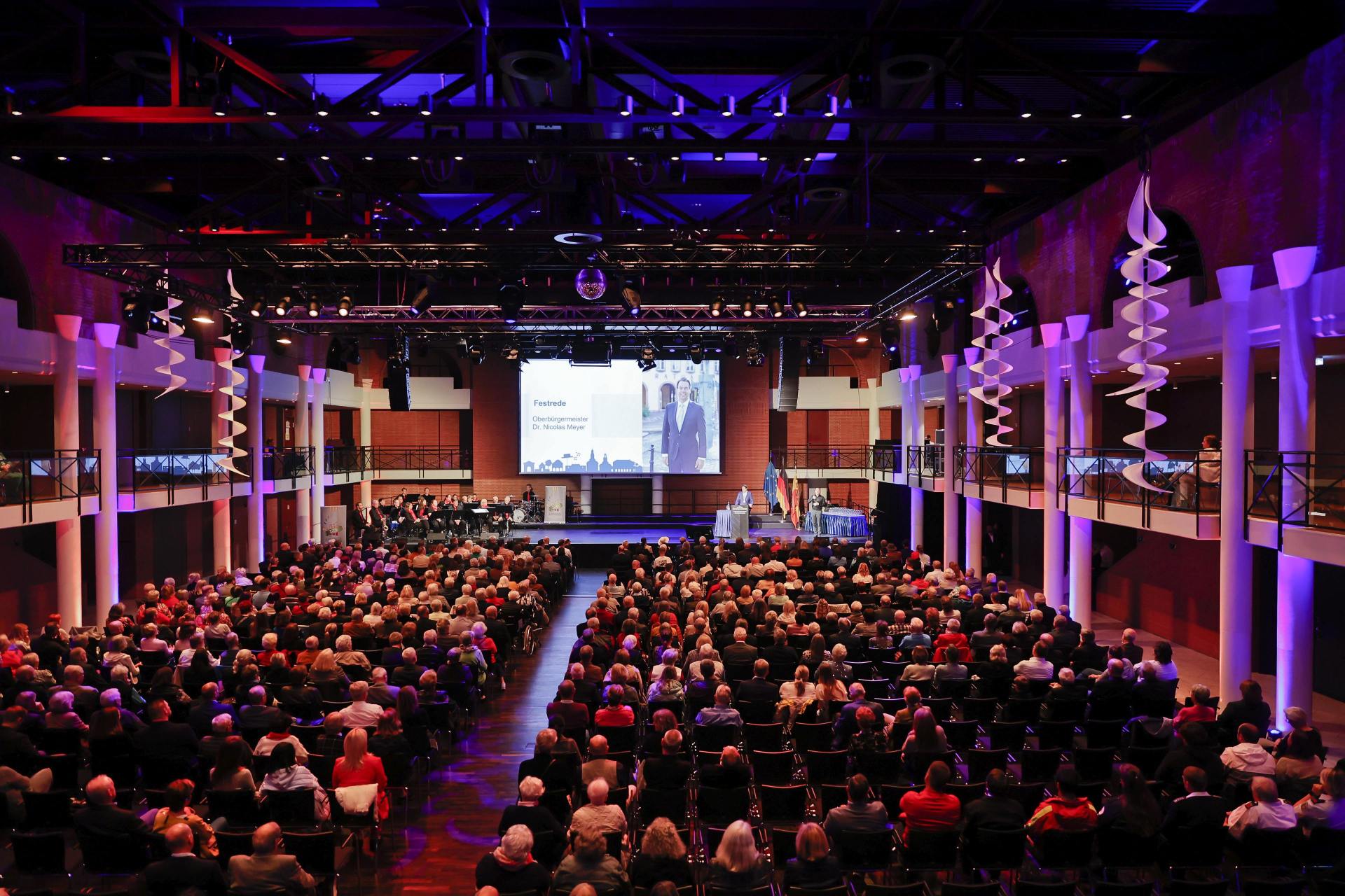 Festliche Veranstaltung mit vielen Menschen in großem Saal
