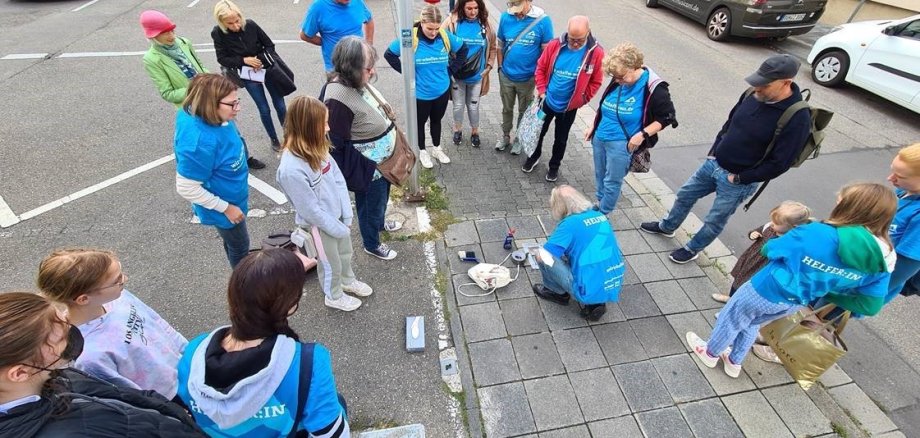 Menschengruppe schaut zu, wie Stolpersteine verlegt werden