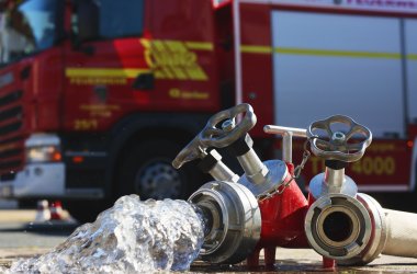 Feuerwehrschlauch vor einem Feuerwehrauto
