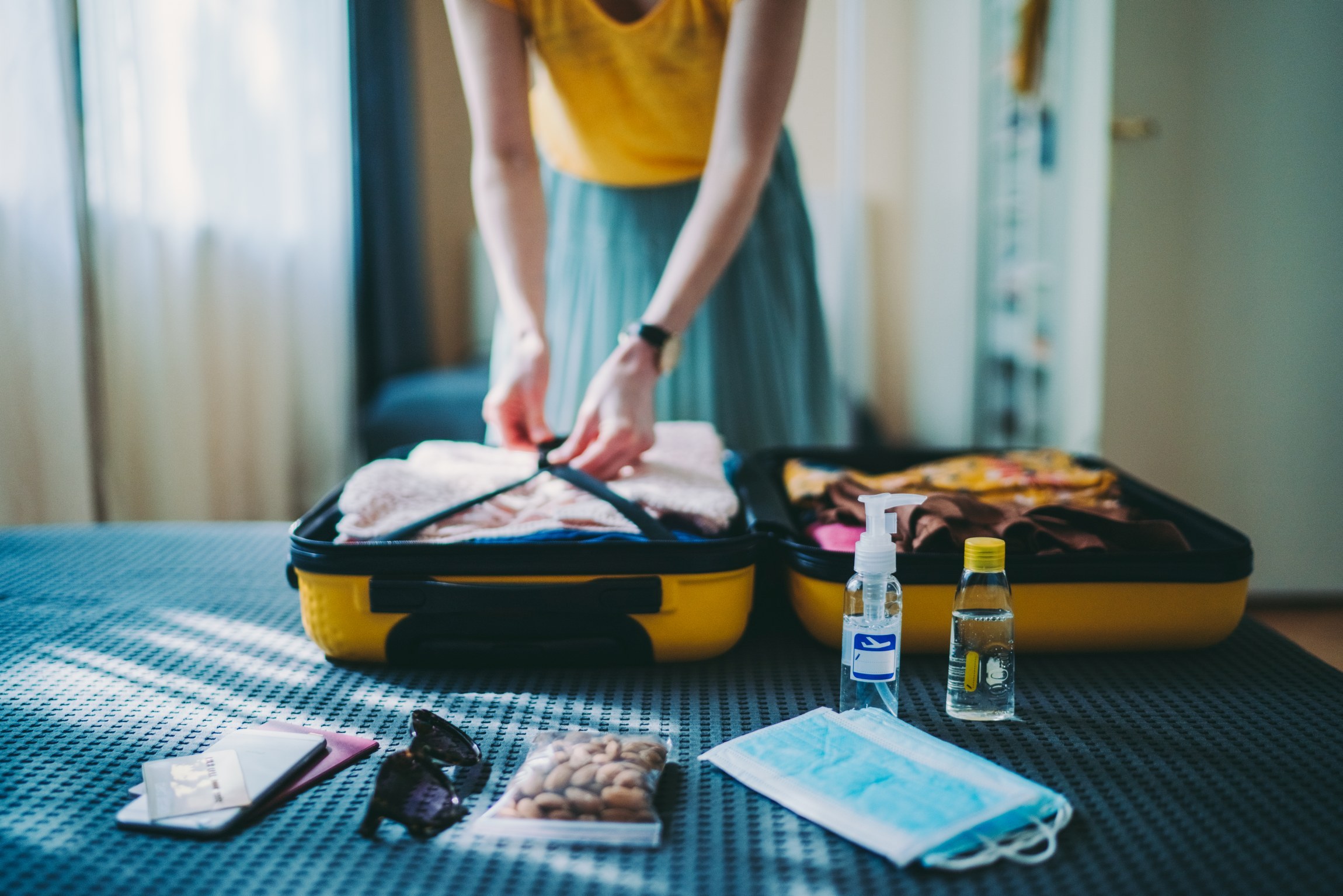 Suitcase packing for travel, COVID-19 Person packt Notfalltasche